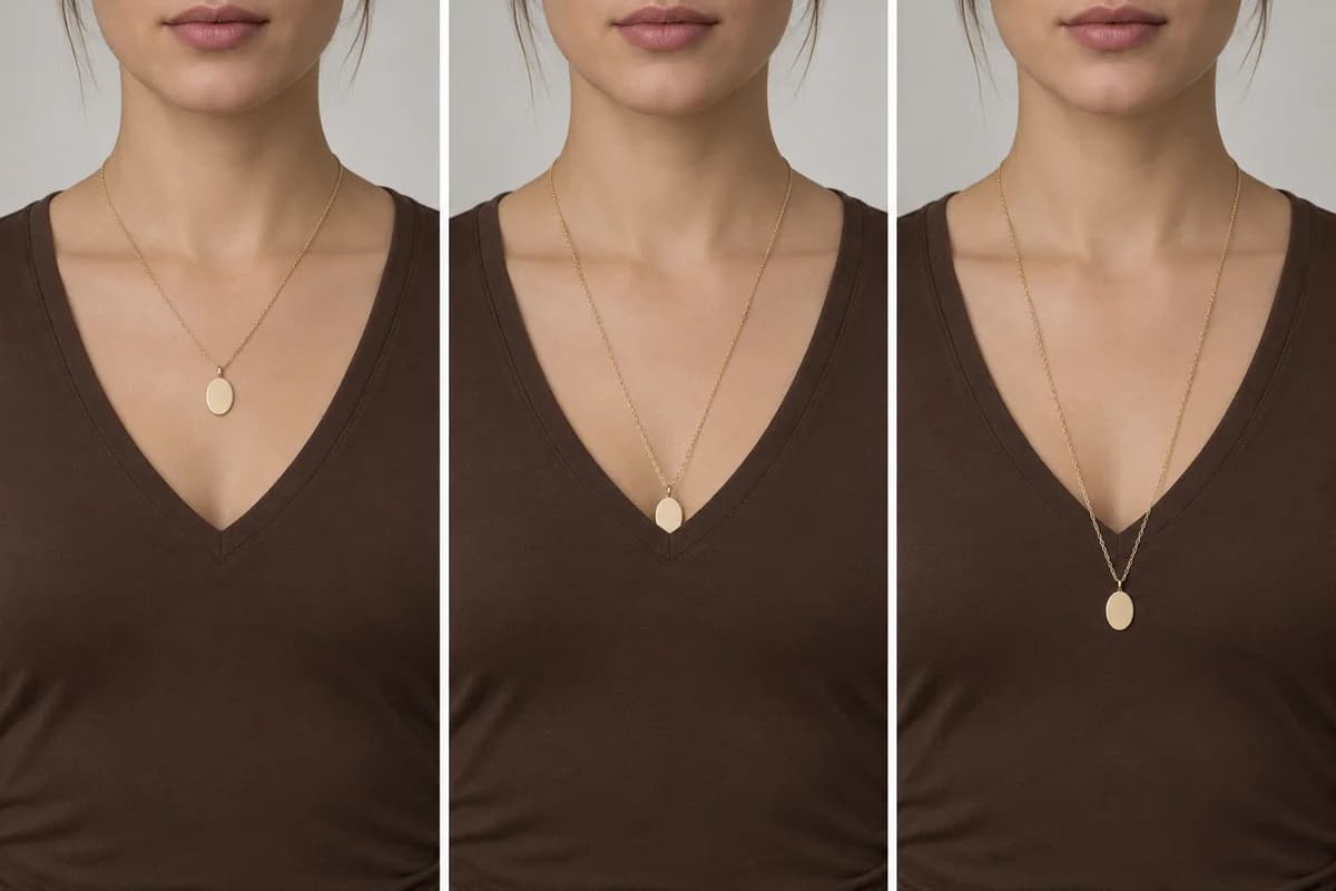 An oval pendant shown inside a V-neck, touching its point, and resting below the opening on the fabric.